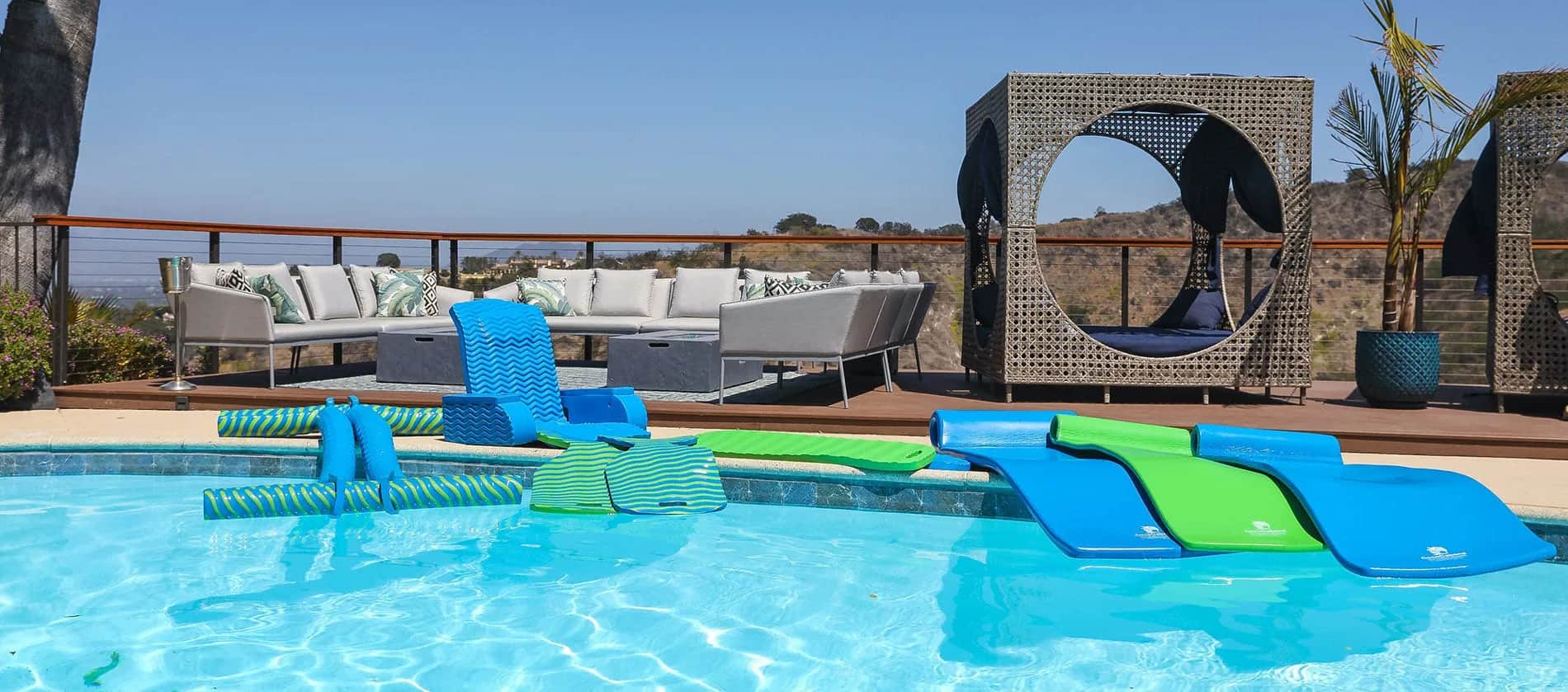 Cococabana foam pool loungers poolside — vibrant colors meet luxury resort energy